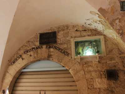 ...una targa che ci avvisa di essere arrivati in corte Cavallerizza. La scritta � situata accanto a un�edicola votiva della Madonna col Bambino e all�insegna della sede della Chiesa cristiana evangelica